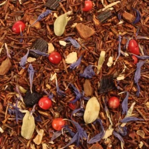 Chai Zanzibar Surprise losse rooibos thee met vanillestukjes, kardemom en roze peperbessen op een sfeervolle achtergrond